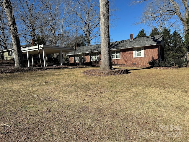 back of property featuring a carport and a lawn