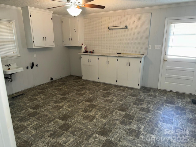 kitchen featuring ceiling fan, sink, crown molding, a textured ceiling, and white cabinets