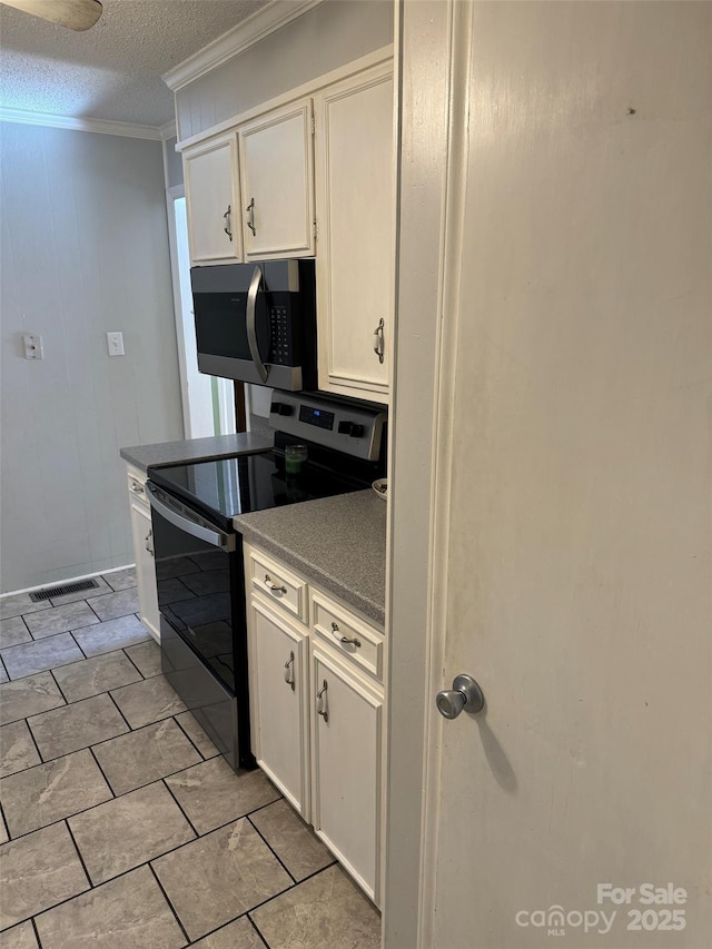 kitchen with white cabinets, a textured ceiling, black electric range oven, and ornamental molding