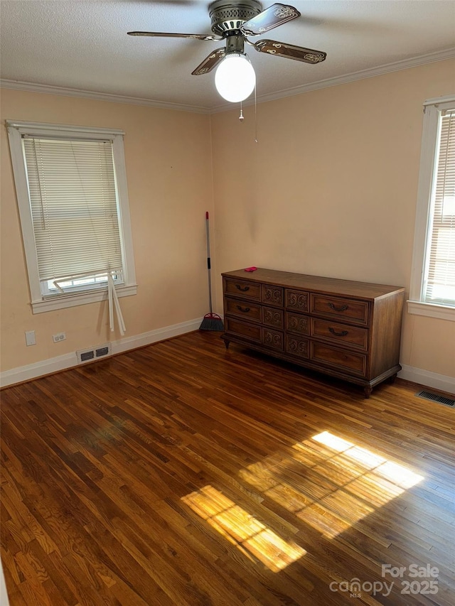 unfurnished bedroom featuring ceiling fan, ornamental molding, a textured ceiling, and hardwood / wood-style flooring