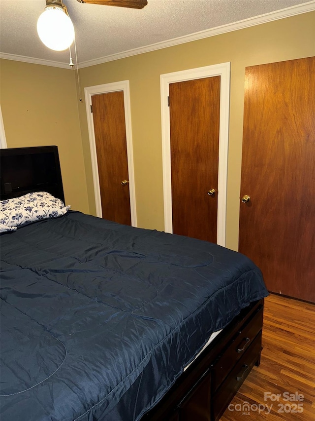 bedroom featuring ceiling fan, ornamental molding, a textured ceiling, and hardwood / wood-style flooring