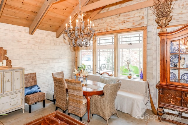 dining area with vaulted ceiling with beams, wooden ceiling, concrete flooring, and a notable chandelier