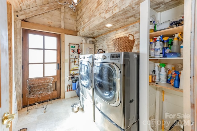 clothes washing area with washing machine and dryer and wooden ceiling