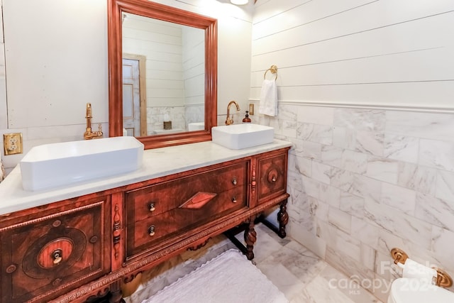 bathroom featuring vanity and tile walls