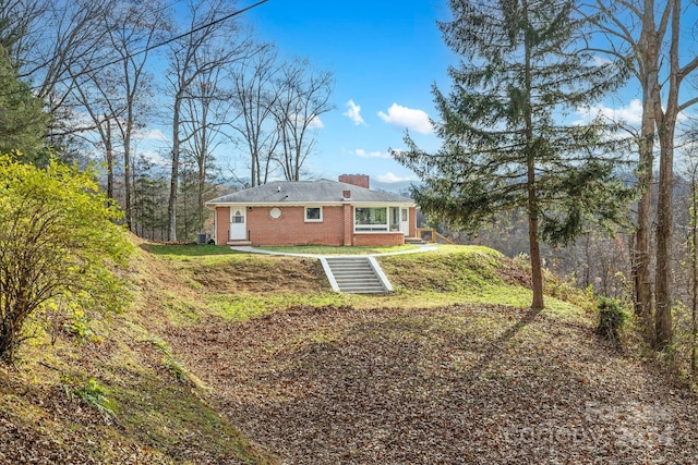 rear view of house featuring a lawn