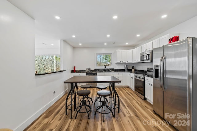 kitchen with white cabinetry, light hardwood / wood-style floors, and appliances with stainless steel finishes