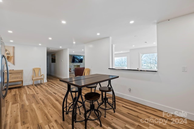 dining space featuring a fireplace and light hardwood / wood-style flooring