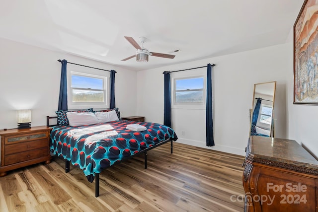 bedroom featuring light hardwood / wood-style floors, multiple windows, and ceiling fan