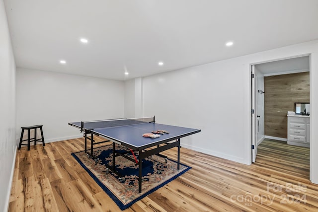 playroom featuring light hardwood / wood-style floors and wooden walls