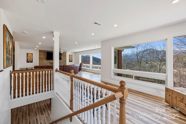 corridor with recessed lighting, visible vents, an upstairs landing, and wood finished floors