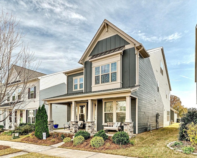 craftsman inspired home featuring a front lawn and covered porch