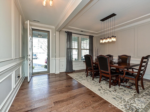 dining room featuring dark hardwood / wood-style flooring, ornamental molding, and a wealth of natural light