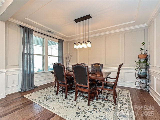 dining area with a notable chandelier, dark hardwood / wood-style floors, and crown molding