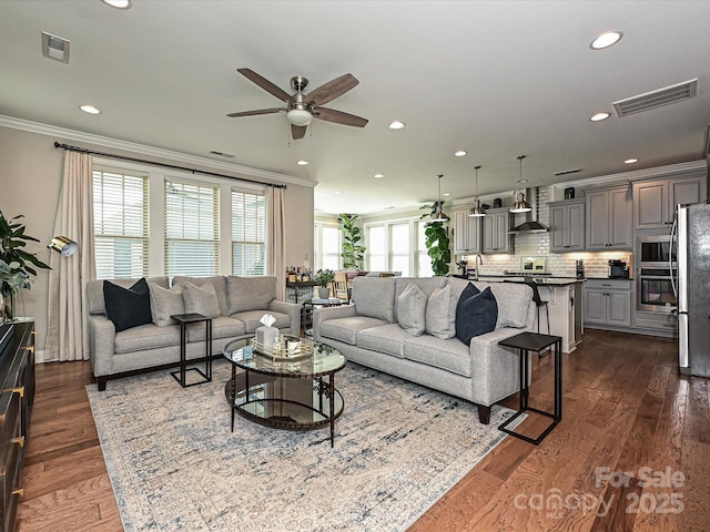 living room with ceiling fan, dark wood-type flooring, and ornamental molding