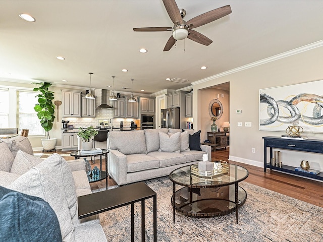 living room featuring ceiling fan, sink, wood-type flooring, and ornamental molding