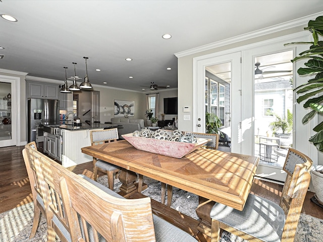 dining room with ceiling fan, a healthy amount of sunlight, dark hardwood / wood-style flooring, and ornamental molding