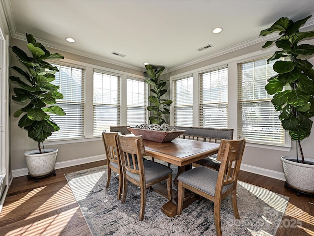 dining space featuring dark hardwood / wood-style flooring, plenty of natural light, and ornamental molding