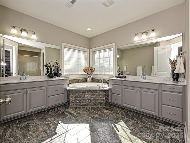 bathroom featuring vanity and independent shower and bath