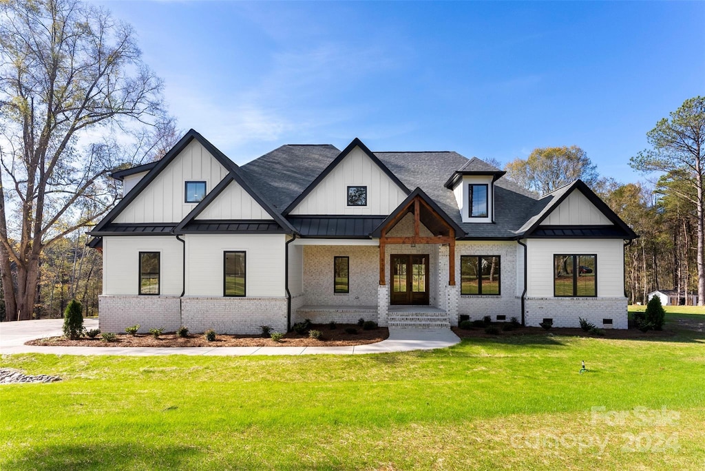 modern farmhouse style home with a front yard and french doors