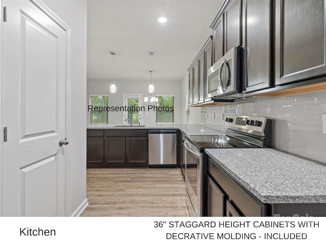 kitchen with hanging light fixtures, light hardwood / wood-style floors, dark brown cabinets, and appliances with stainless steel finishes