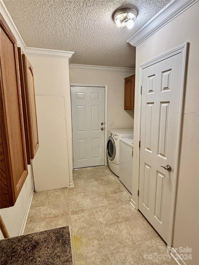 laundry area with washer and dryer, light tile patterned floors, a textured ceiling, and crown molding