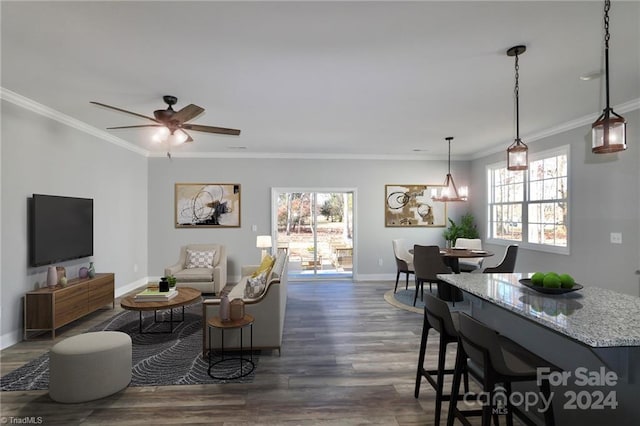 living room featuring ceiling fan with notable chandelier, dark hardwood / wood-style floors, and crown molding