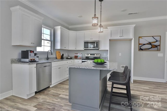 kitchen with white cabinets, a kitchen island, and appliances with stainless steel finishes