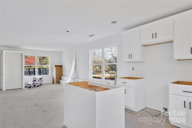 kitchen with a center island, white cabinetry, and plenty of natural light