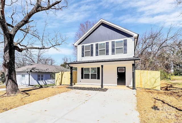 view of front of property featuring a gate, board and batten siding, a porch, and fence