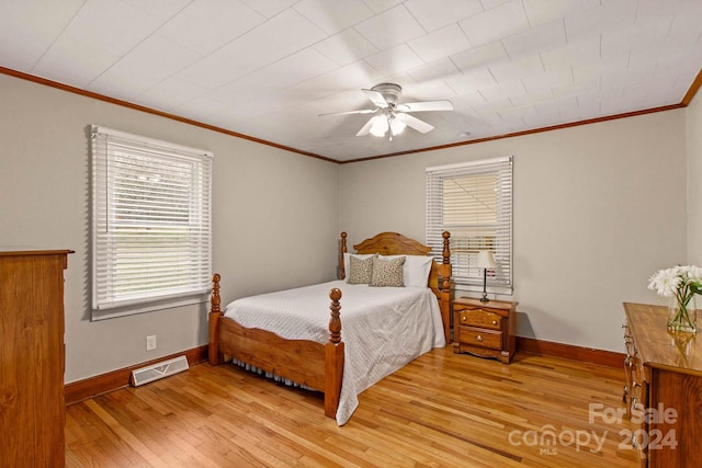 bedroom featuring ceiling fan, crown molding, and hardwood / wood-style flooring