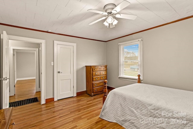 bedroom featuring light hardwood / wood-style flooring, ceiling fan, and crown molding