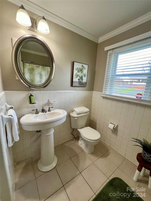 bathroom featuring tile patterned floors, toilet, crown molding, and tile walls