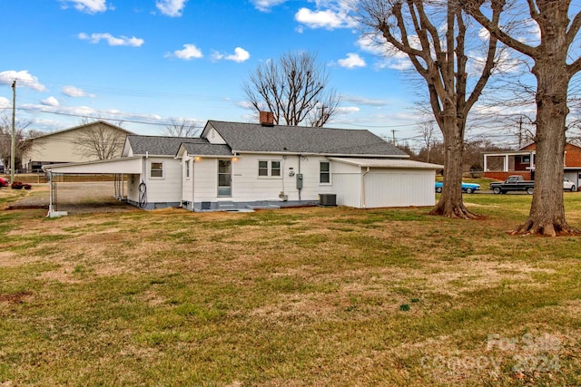 back of house featuring a carport, a lawn, and central AC