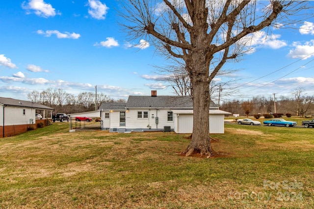 rear view of house featuring a yard and central AC