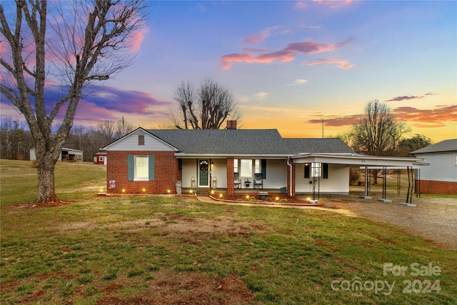 single story home with a carport, covered porch, and a lawn