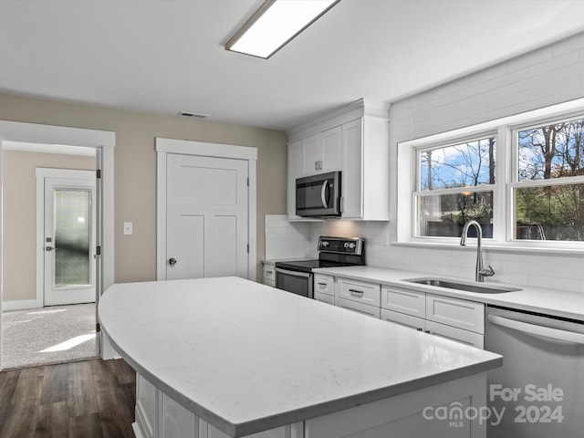 kitchen with white cabinetry, a center island, dark wood-type flooring, and appliances with stainless steel finishes