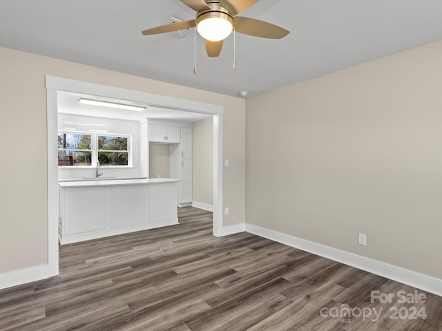 unfurnished living room with ceiling fan, dark hardwood / wood-style flooring, and sink