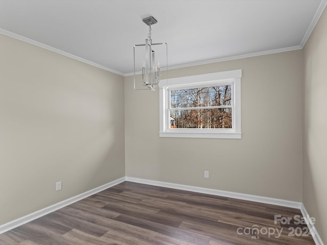 empty room with a chandelier, dark hardwood / wood-style flooring, and ornamental molding