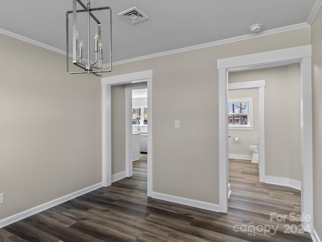 unfurnished dining area with crown molding, dark wood-type flooring, and an inviting chandelier