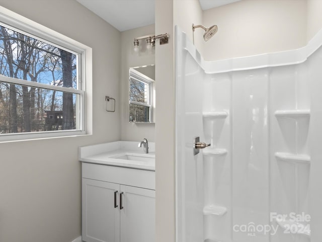 bathroom featuring a shower, a wealth of natural light, and vanity