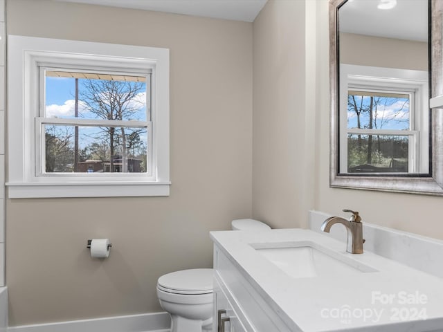 bathroom with vanity, a healthy amount of sunlight, and toilet