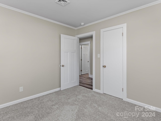 unfurnished bedroom featuring carpet flooring and crown molding