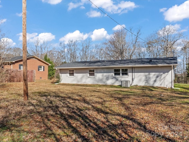 back of property with a yard and central AC unit