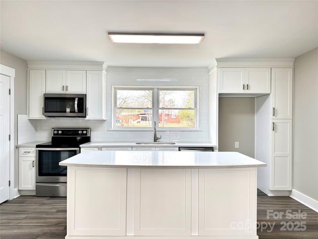 kitchen with stainless steel appliances, white cabinetry, and sink