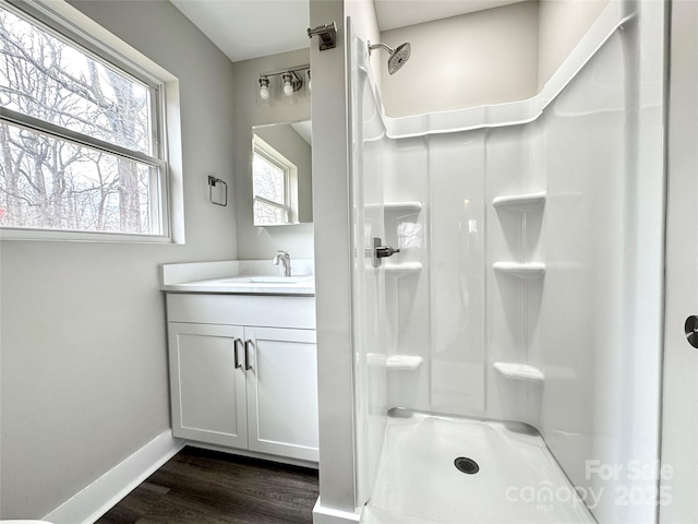 bathroom with hardwood / wood-style flooring, vanity, and walk in shower