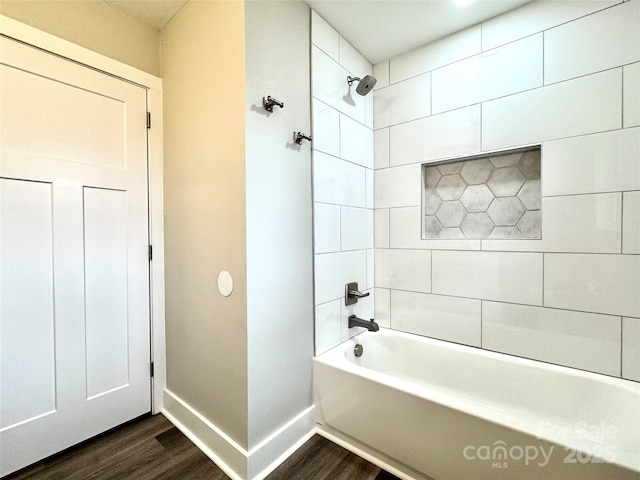 bathroom featuring wood-type flooring and tiled shower / bath