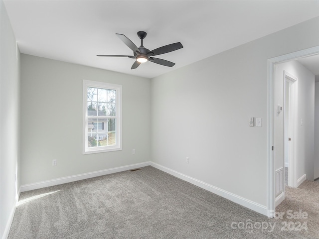 carpeted spare room featuring ceiling fan