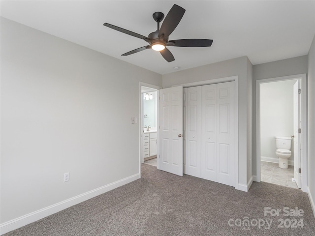 unfurnished bedroom with carpet flooring, connected bathroom, a closet, and ceiling fan