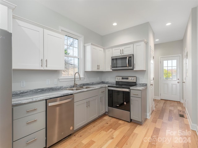 kitchen with a wealth of natural light, sink, light hardwood / wood-style flooring, and appliances with stainless steel finishes