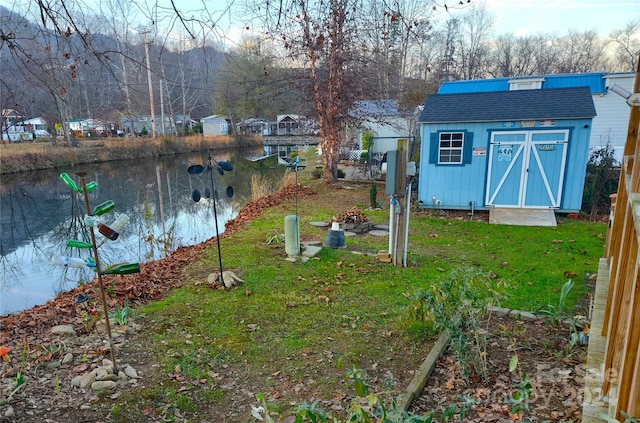 view of yard featuring a water view and a storage unit